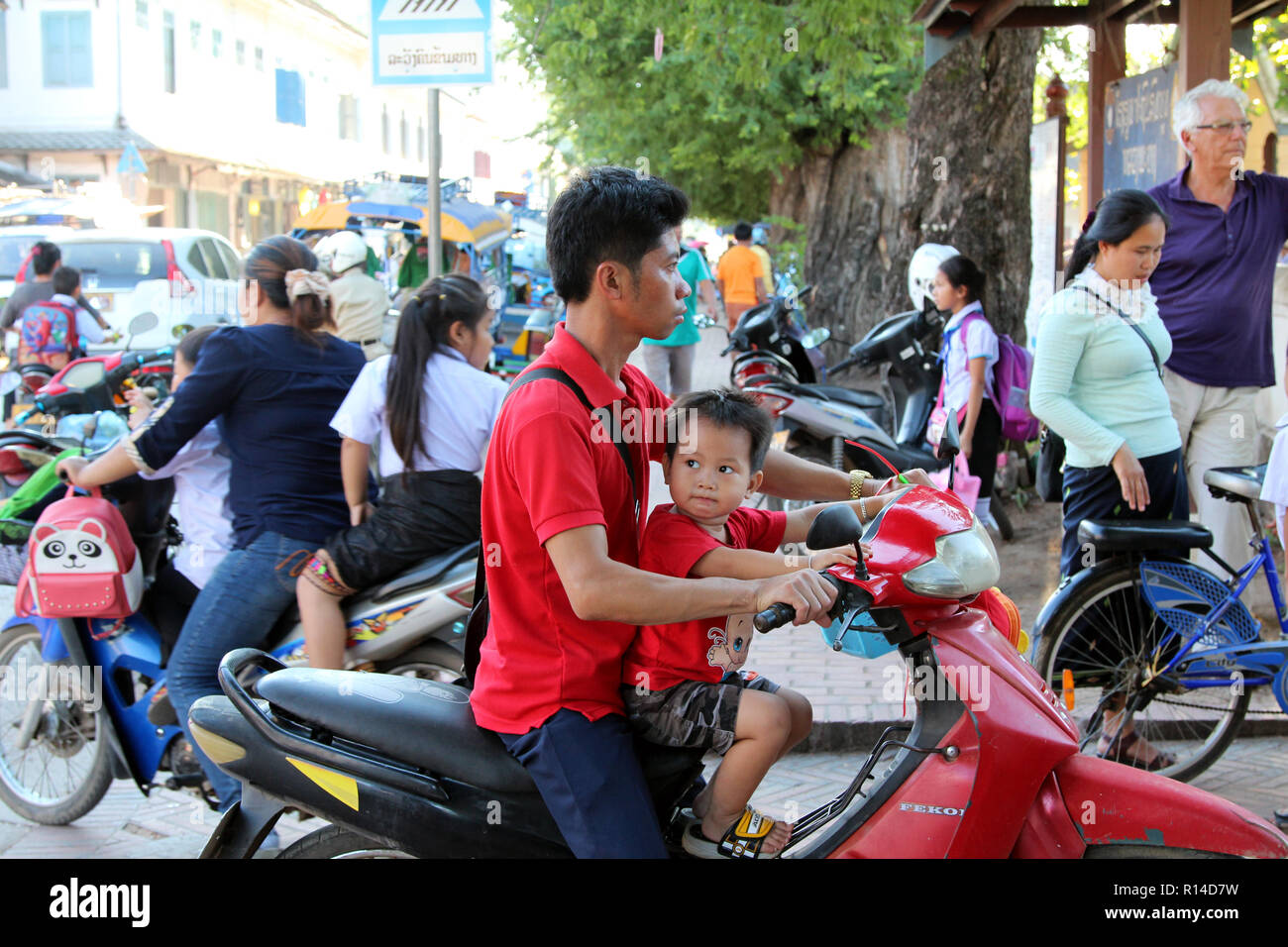 Father and son ride a moto home after school, Hanoi, Vietnam Stock Photo