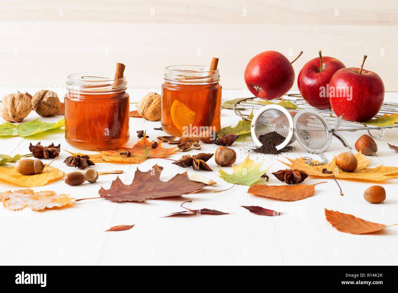 White wooden table with 2 glasses of tea with fall, autumn decoration ...