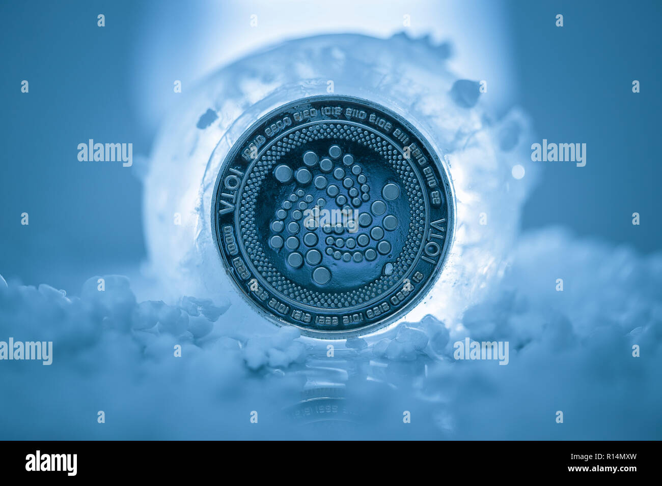 Iota cryptocurrency physical coin placed next to ice ball and fake snow in  the blue background Stock Photo - Alamy