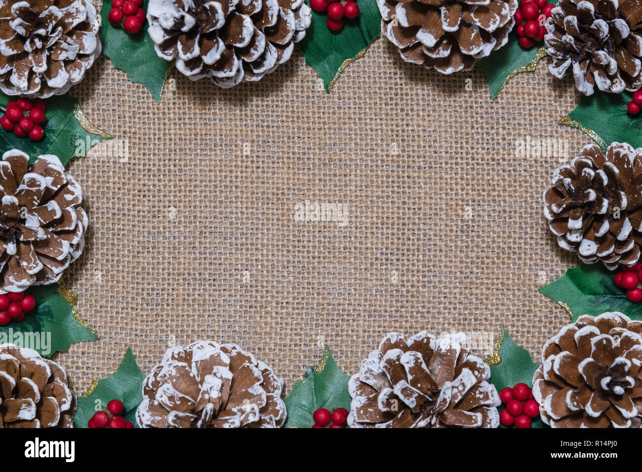 Christmas flat-lay frame of pinecones, holly leaves, and red berries on ...