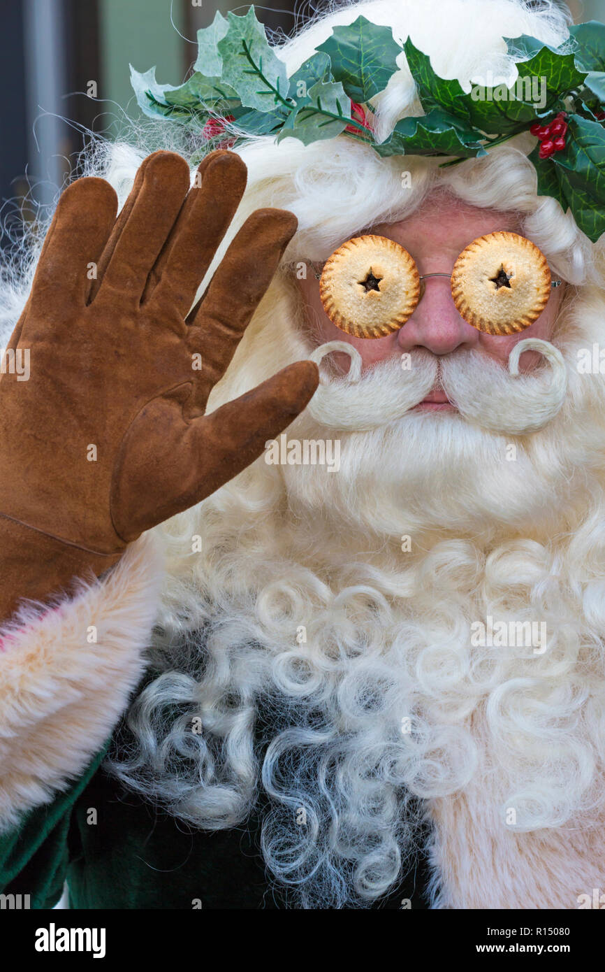 Santa Claus dressed in green Victorian Father Christmas costume at Victorian Festival of Christmas with mince pies as eyes - surreal surrealism Stock Photo