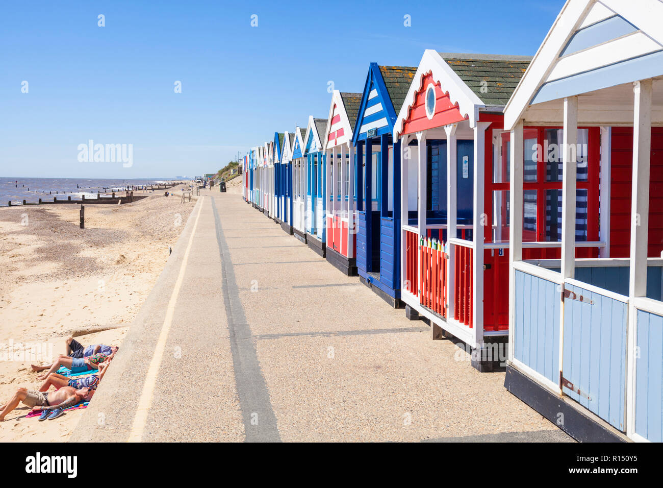 Southwold beach huts brightly painted beach huts holidaymakers at