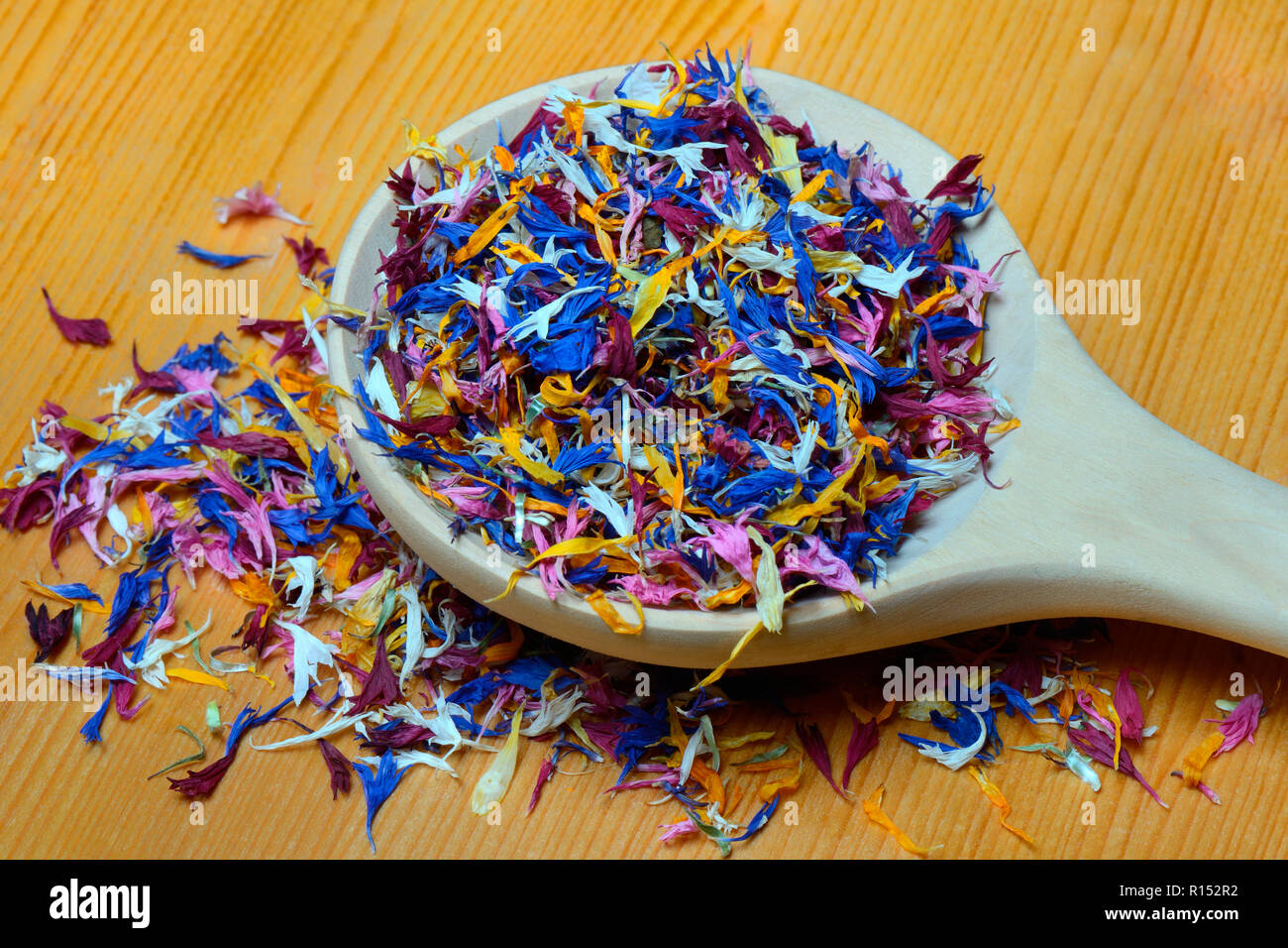 Bluetenblaetter in Holzloeffel, essbare Blueten, Centaurea cyanus, Calendula officinalis, Helianthus annuus Stock Photo