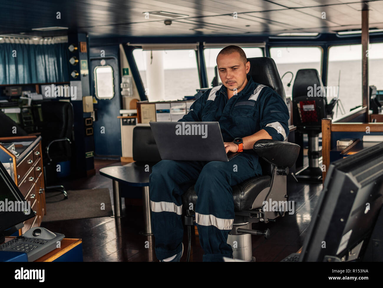 Marine navigational officer or technician is using laptop or notebook ...