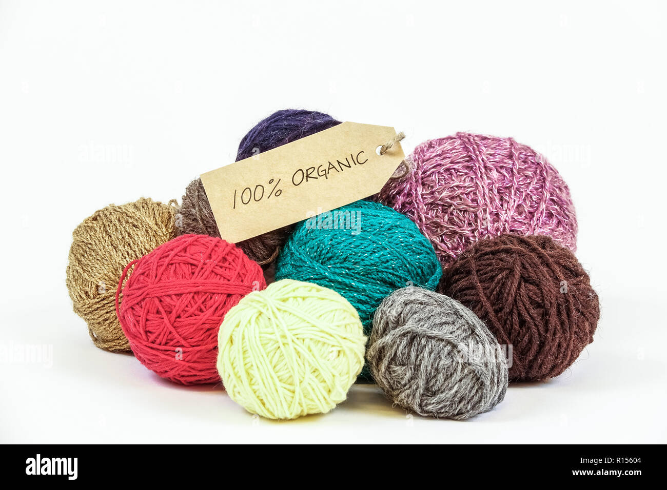 Organic wool. Colorful balls of yarn. Knitting threads. Eco textile tag. White background. Stock Photo