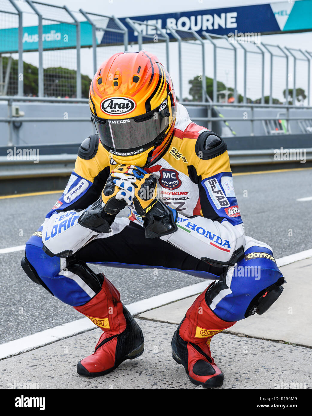 Motorcycle racer stretching on pit lane Stock Photo