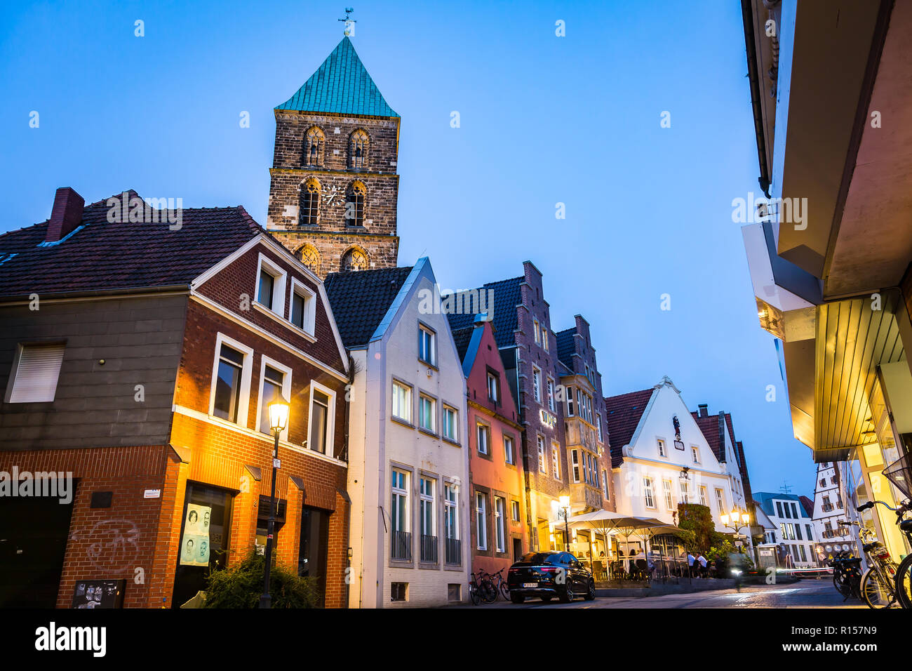 Rheine, Germany - September 5, 2018: street in the night, belfry tower of medieval Sankt Antonius Basilica in the backgroung Stock Photo