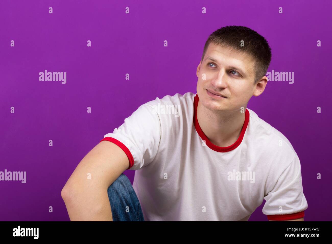 young handsome man posing on purple background Stock Photo
