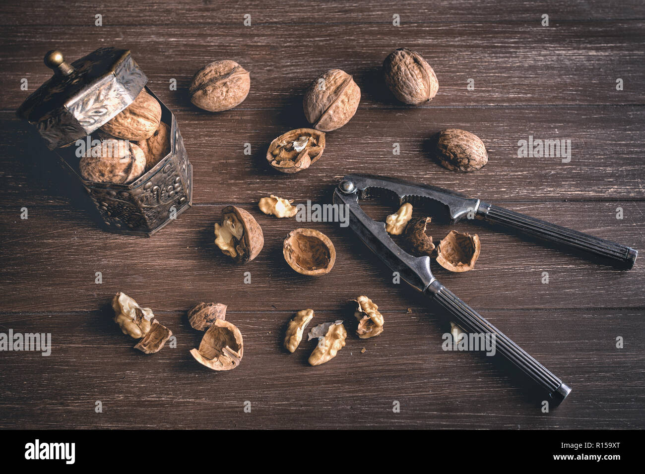 Walnuts lying on a brown tray with a nutcracker Stock Photo