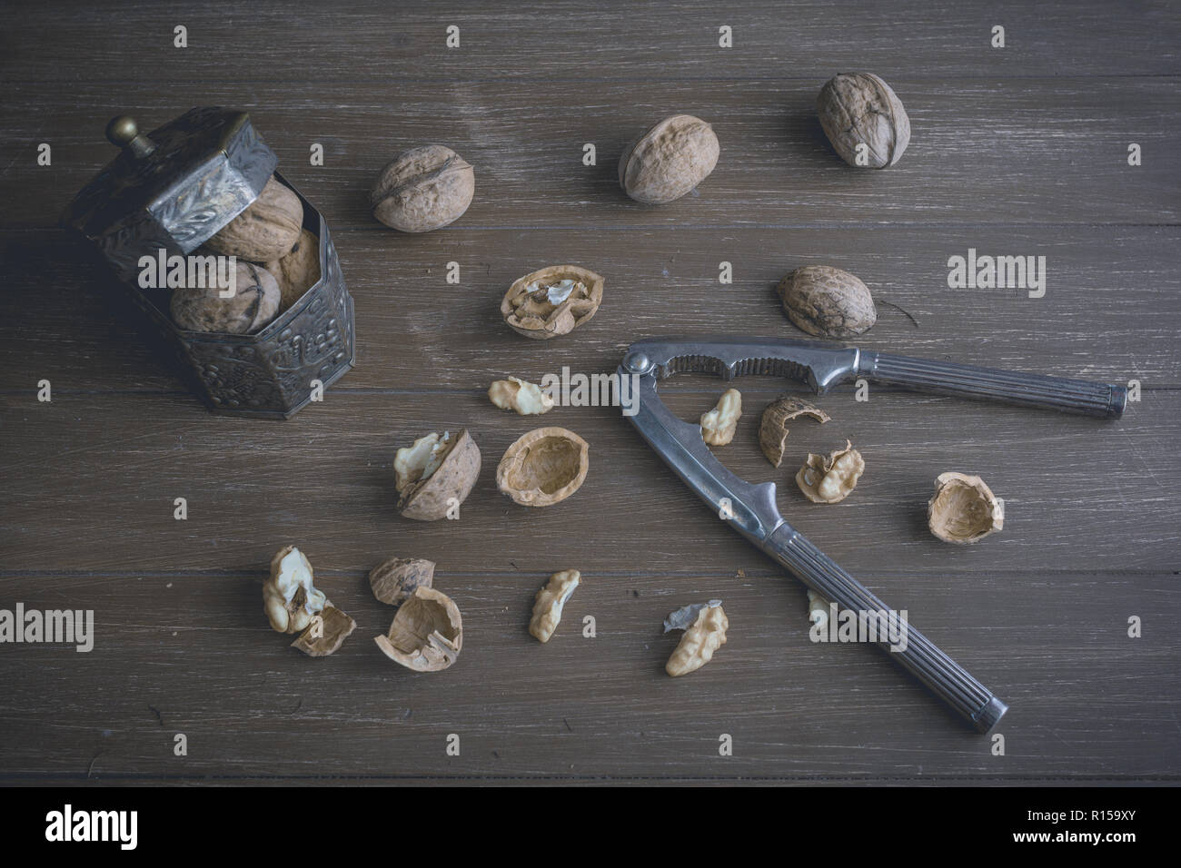 Walnuts lying on a brown tray with a nutcracker Stock Photo