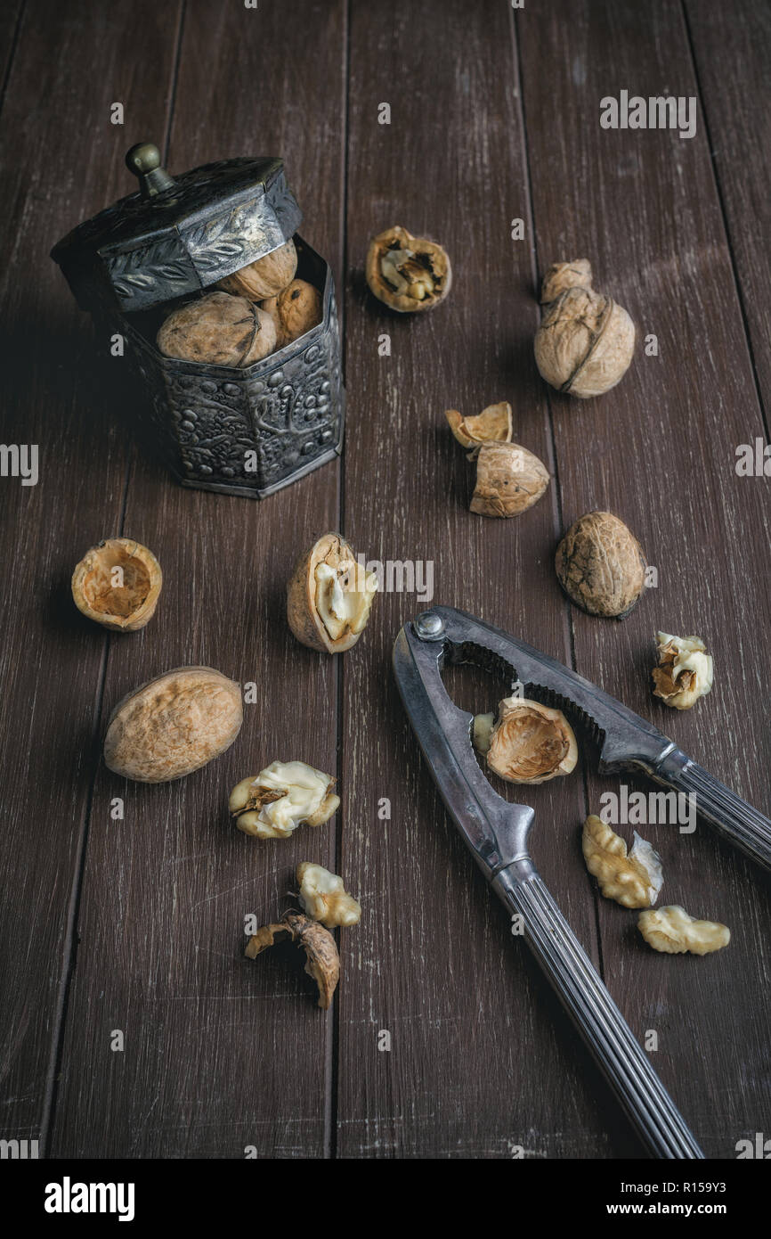 Walnuts lying on a brown tray with a nutcracker Stock Photo