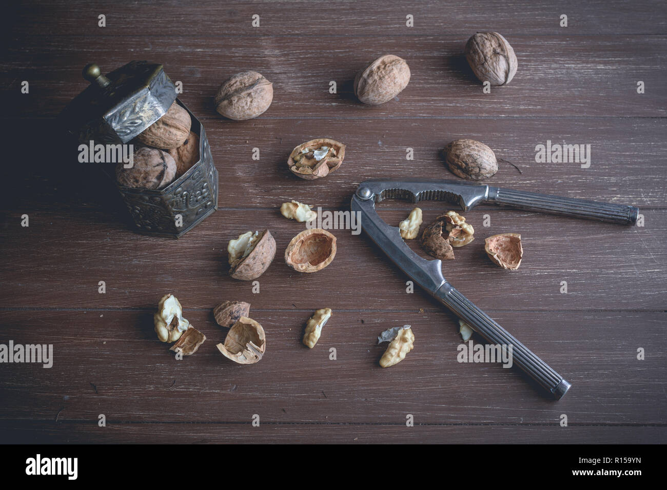 Walnuts lying on a brown tray with a nutcracker Stock Photo