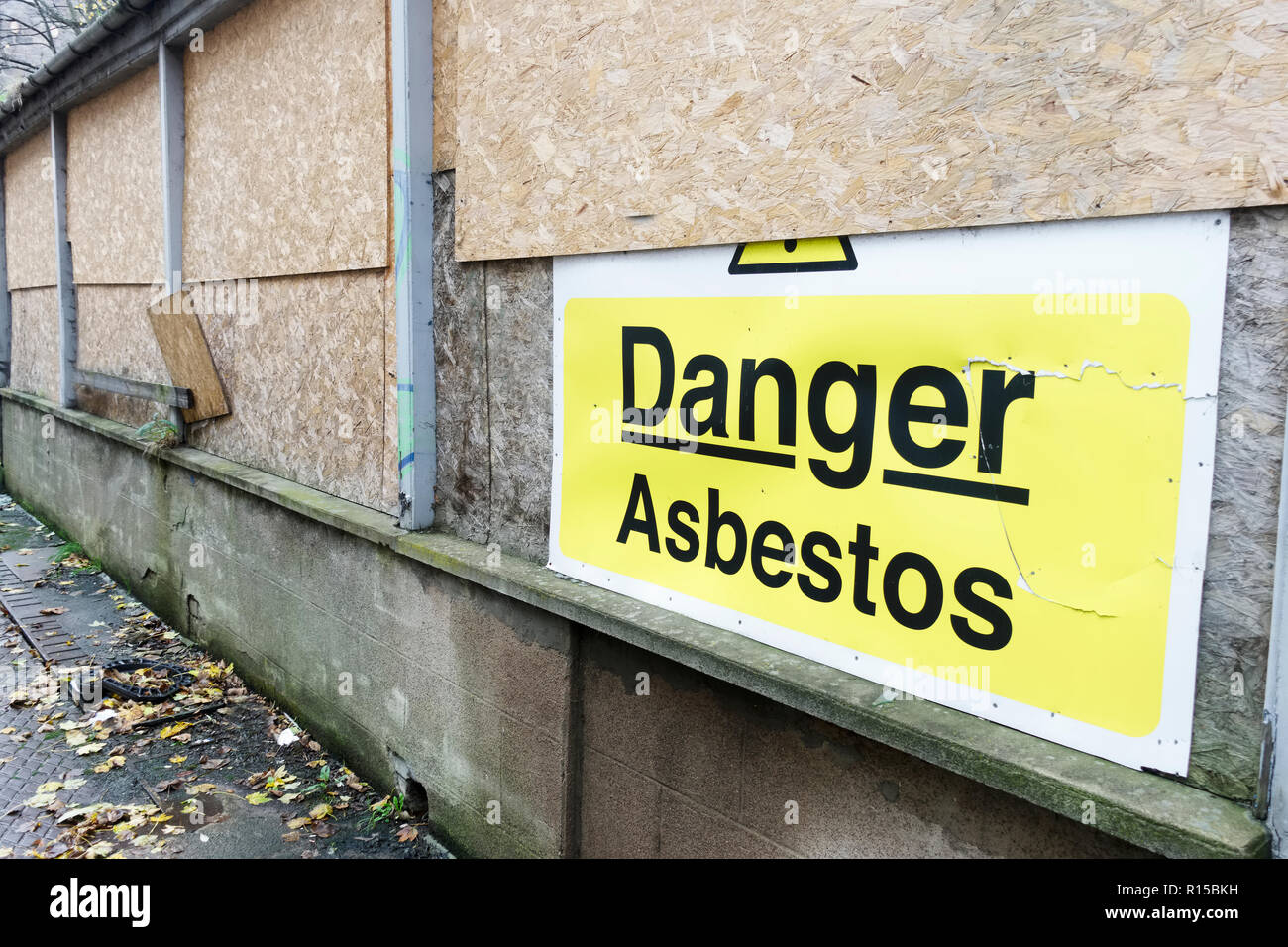 Asbestos danger sign at building construction site refurbishment of old