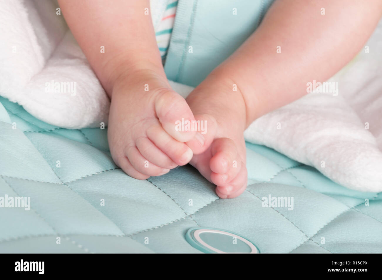 Legs of a newborn baby lying on the bed. Tinted and blur. Selective focus Stock Photo