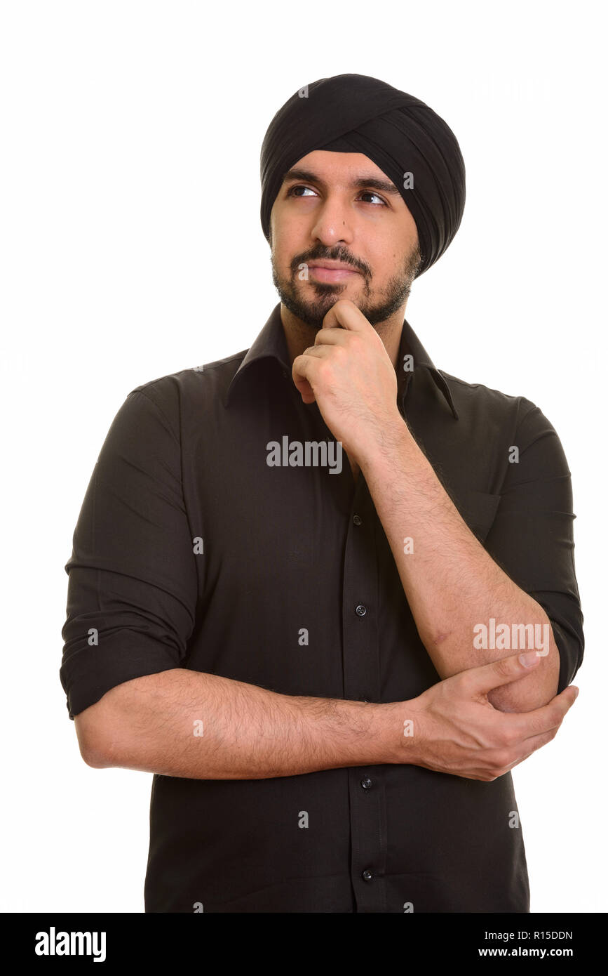 Portrait of young handsome Indian Sikh male thinking Stock Photo