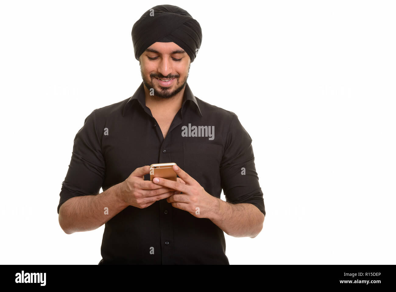 Young happy Indian Sikh using mobile phone Stock Photo