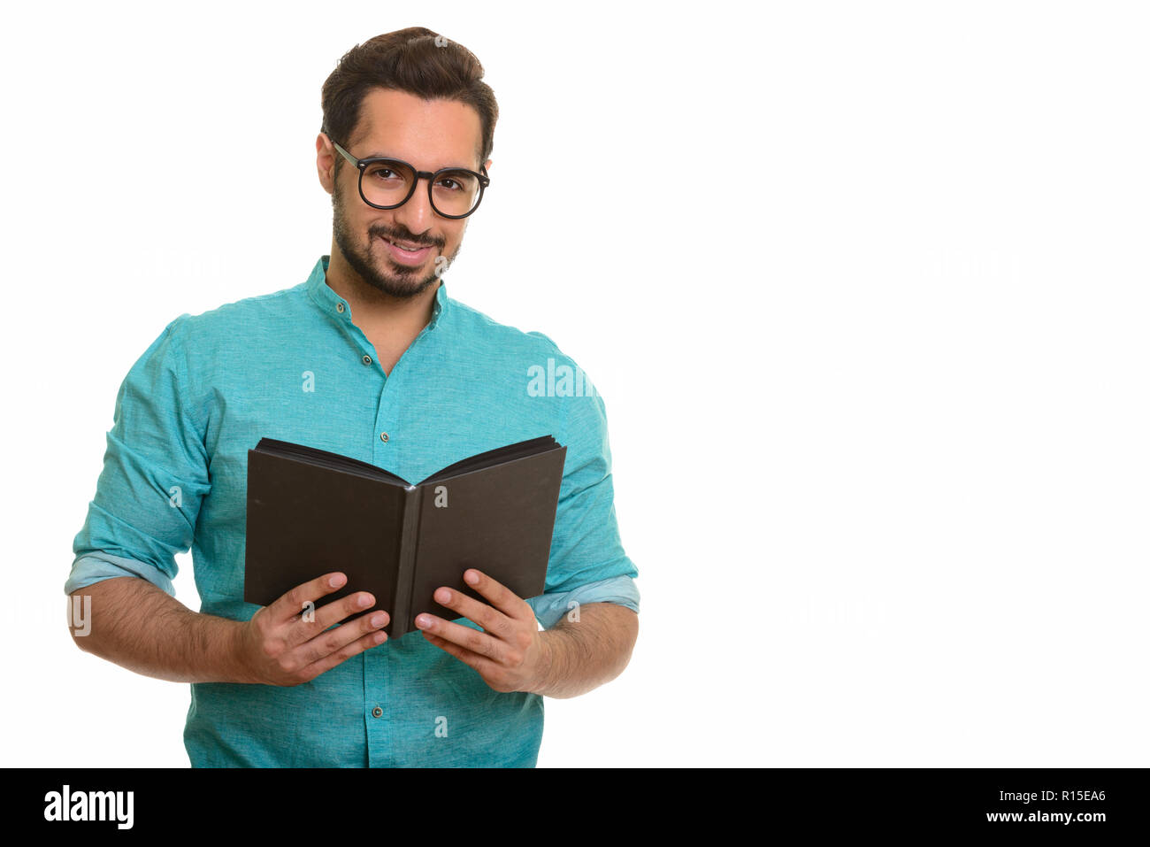 Portrait of young happy Indian man holding book Stock Photo
