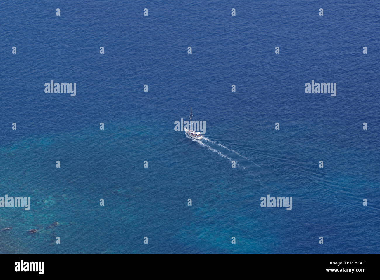 View from above on the single sailing boat in open sea. View from Cabo Girao on Portuguese island of Madeira Stock Photo