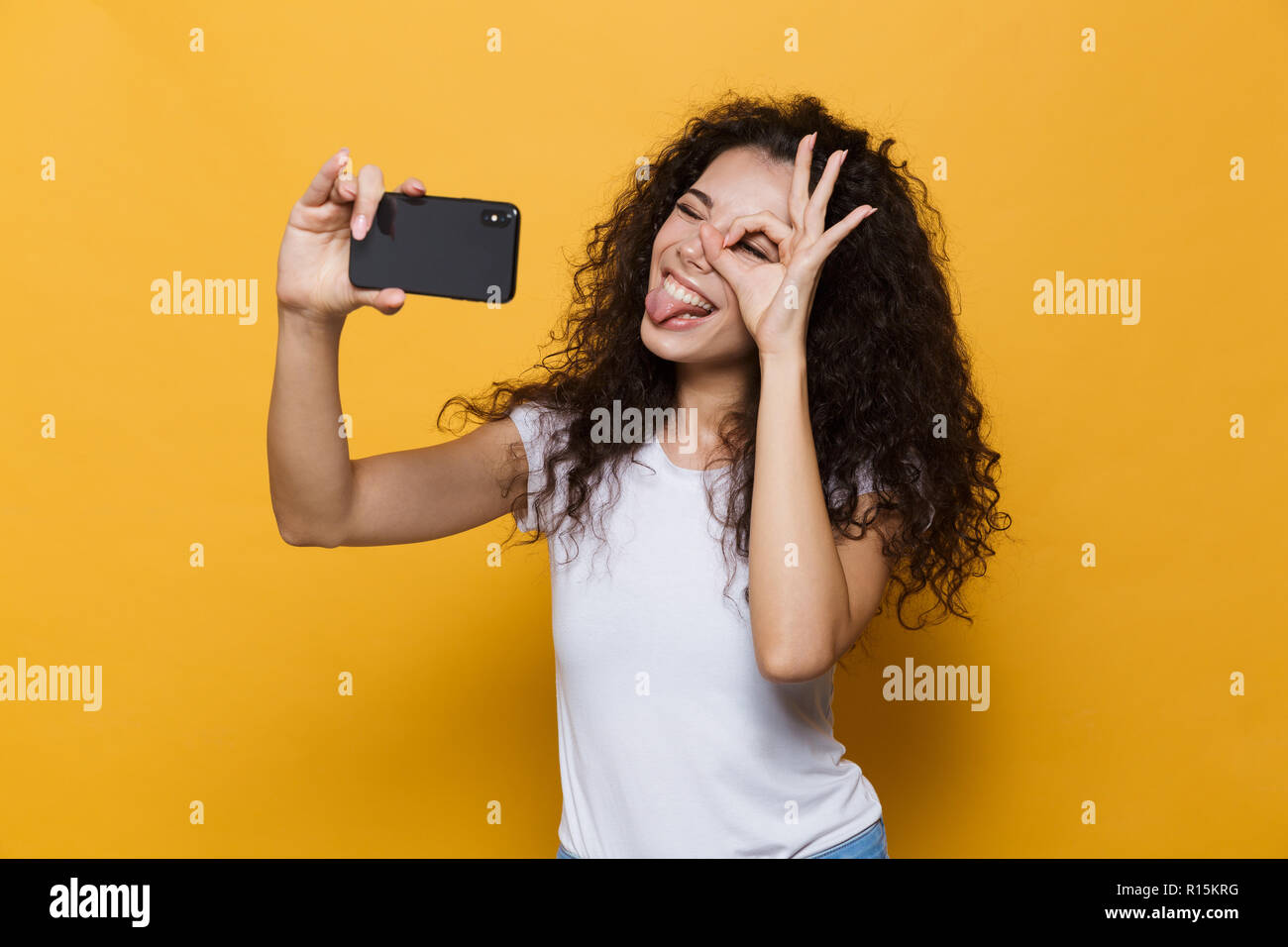 Image of an excited happy cute young woman posing isolated over yellow ...