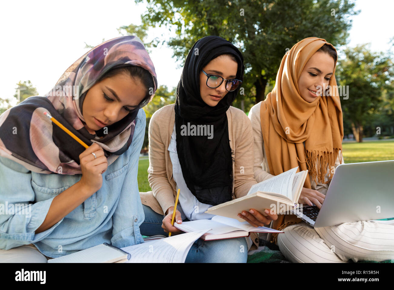 Photo of a happy young arabian women students using laptop computer and ...