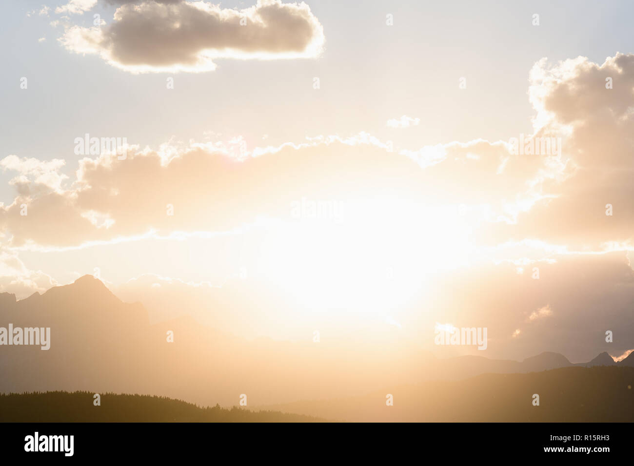Sun peaks out from behind the clouds over Crowsnest Mountain and Seven Sisters Mountain Stock Photo