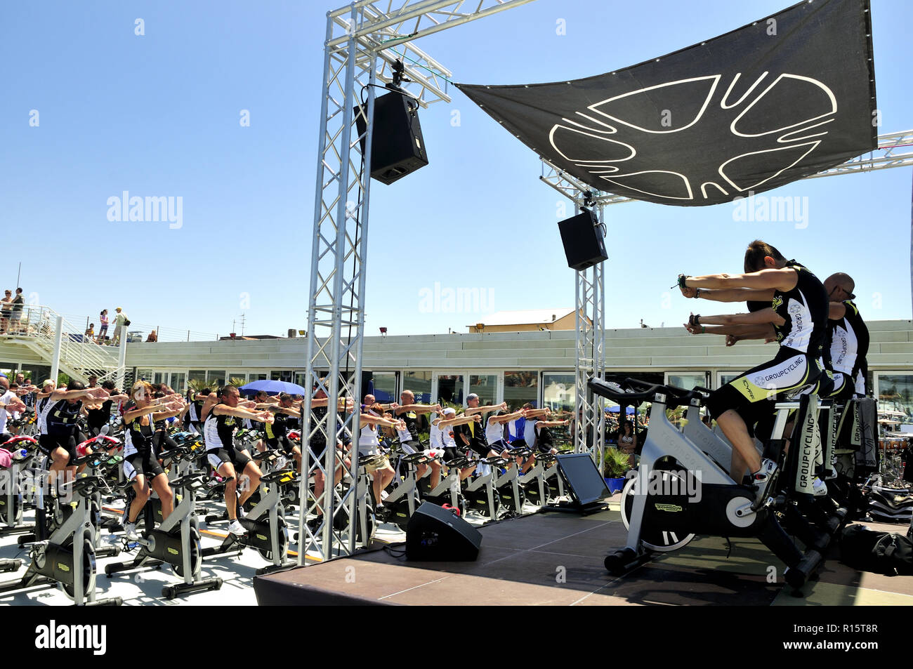 Group of people warming up during a spinning outdoors class. Stock Photo