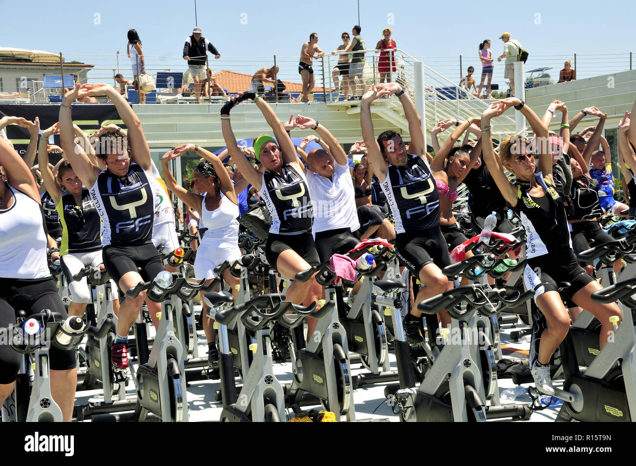 Group of people stretching  in a spinning outdoor class (male and female adults). Stock Photo