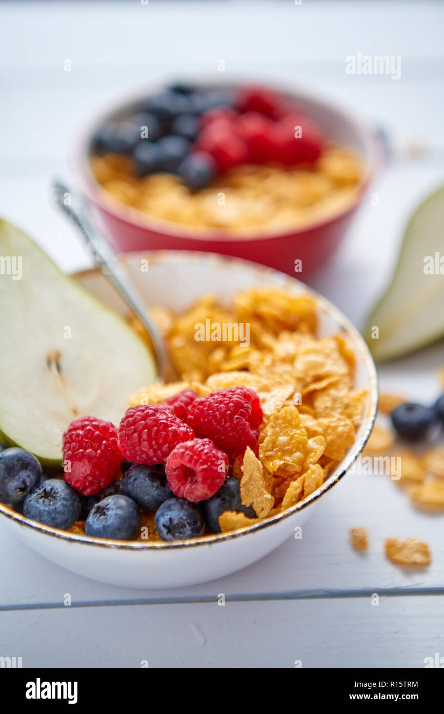 Golden cornflakes with fresh fruits of raspberries, blueberries and ...