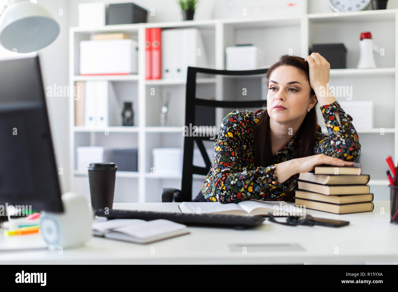 A Young Girl Sitting In The Office At The Computer Table And Lay