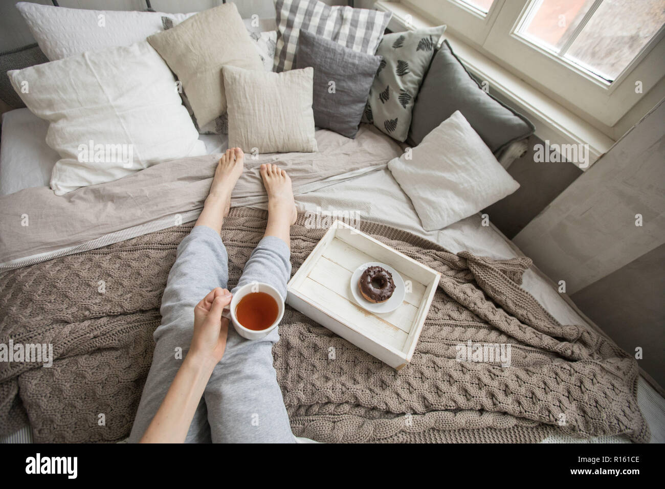 Crop woman having breakfast on bed Stock Photo