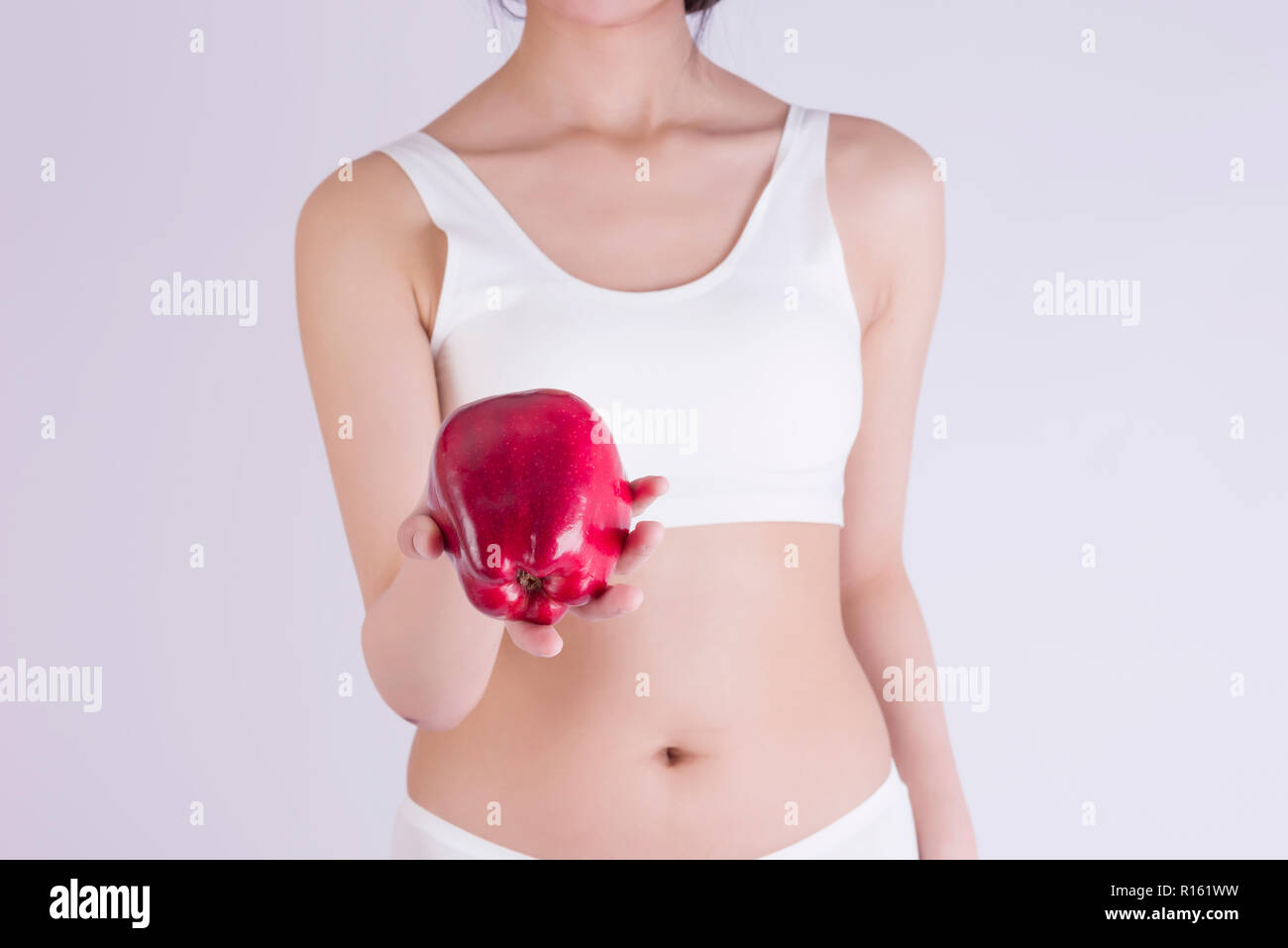Woman holding a fresh apple, and perfect slim body, diet, healthy lifestyle. Stock Photo