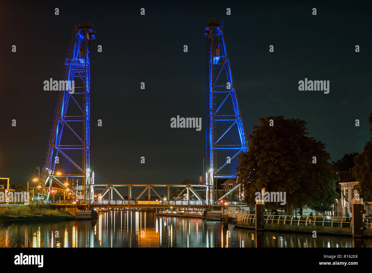 A lifting bridge over a canal is illuminated by blue lights Stock Photo