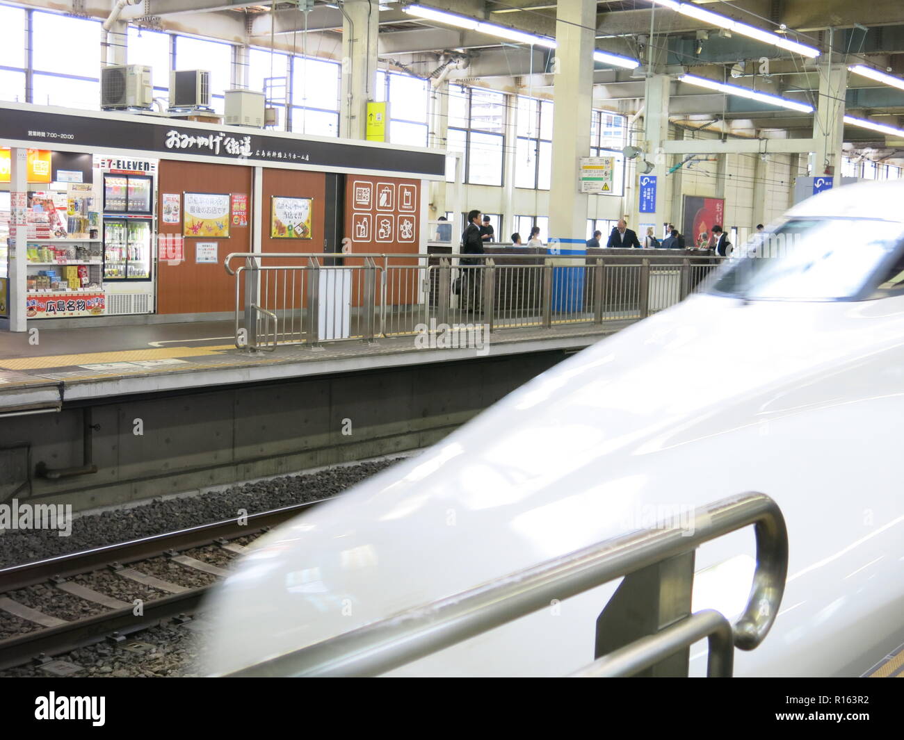 The white pointed nose of Japan's Bullet train is an iconic sight as it rushes through the station Stock Photo