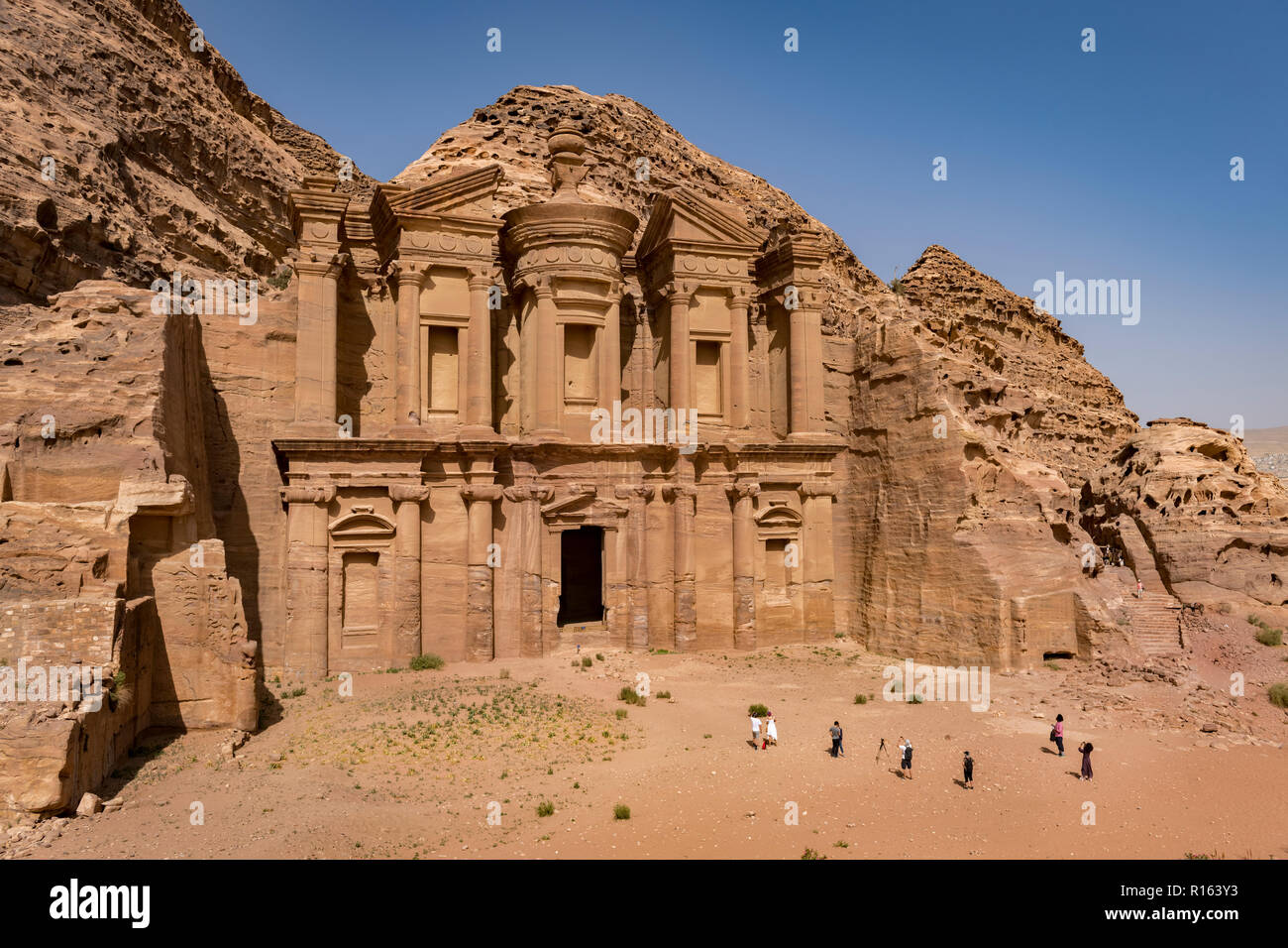 Tourist enjoying the grandeur of Al Deir or The Monastery at Petra in Jordan Stock Photo