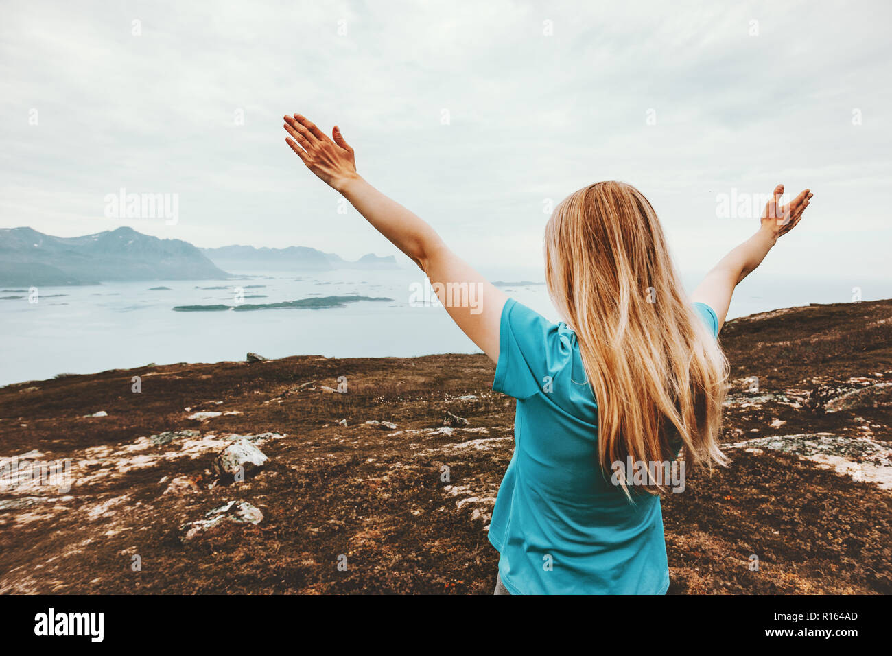 Woman raised hands enjoying landscape traveling in mountains healthy lifestyle adventure vacations outdoor success positive emotions blonde girl Stock Photo