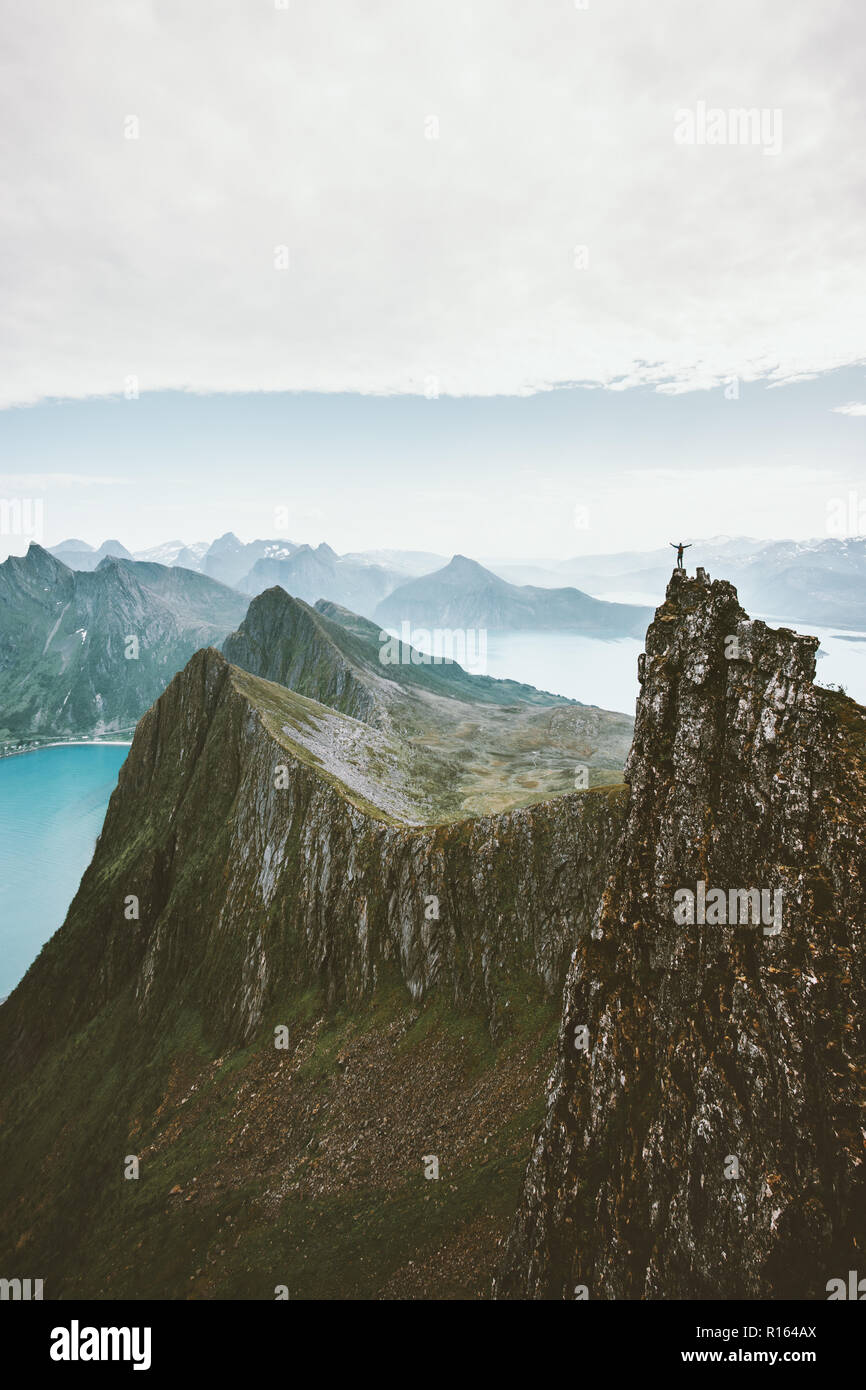 Man climbing in Norway traveler standing on cliff rocky mountain adventure extreme lifestyle vacations aerial view landscape Stock Photo