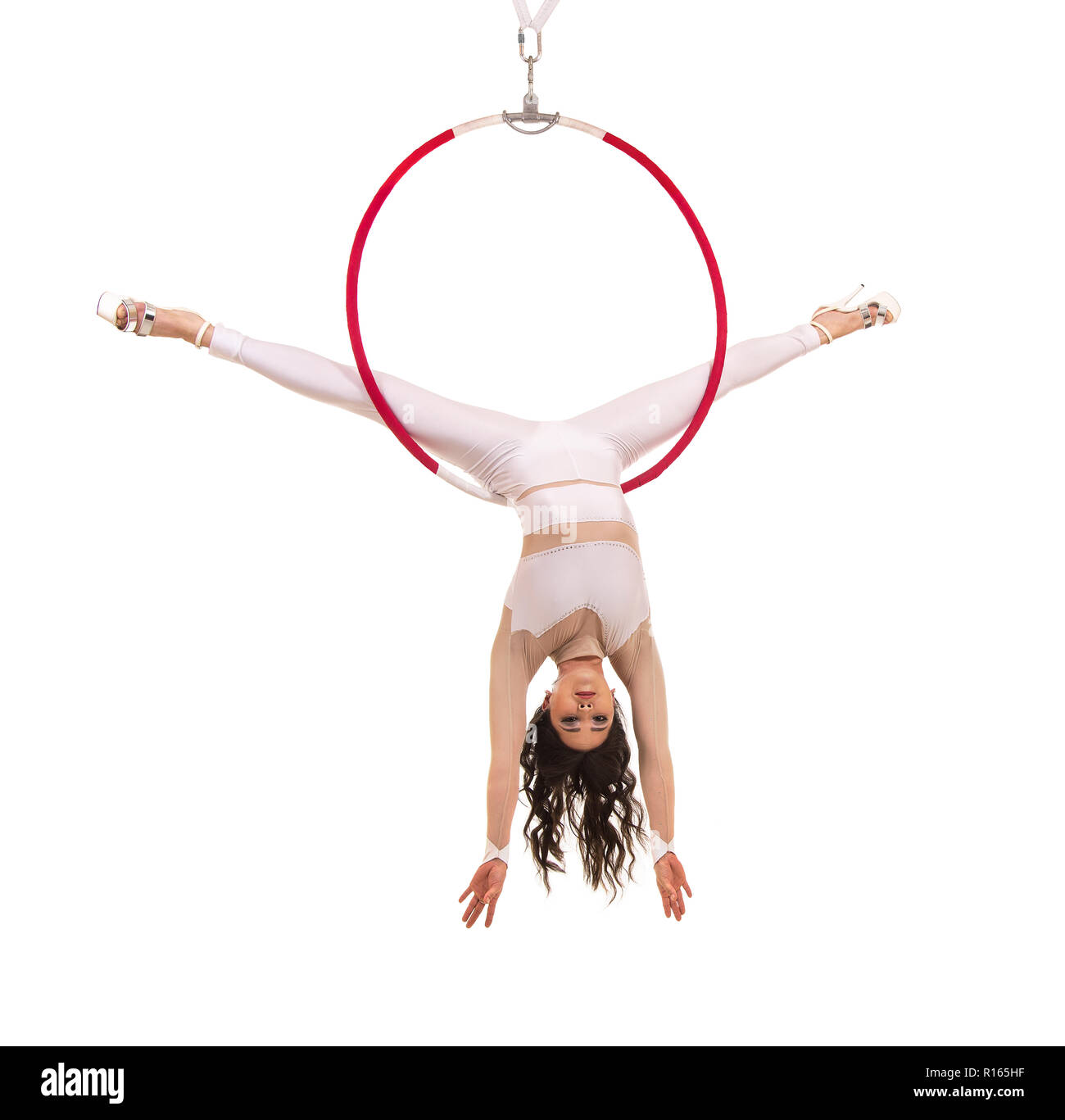 A young woman performs the acrobatic elements in the air ring. Studio ...