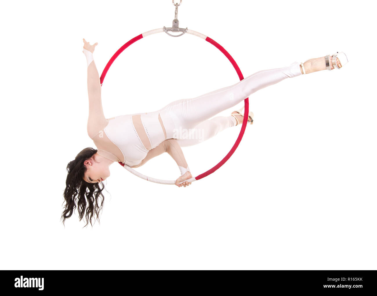 A young woman performs the acrobatic elements in the air ring. Studio ...