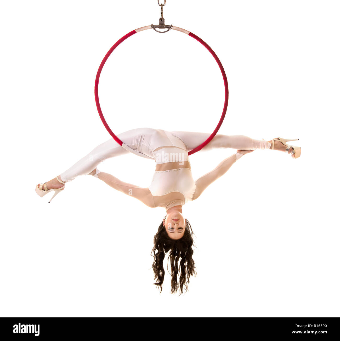 A young woman performs the acrobatic elements in the air ring. Studio ...