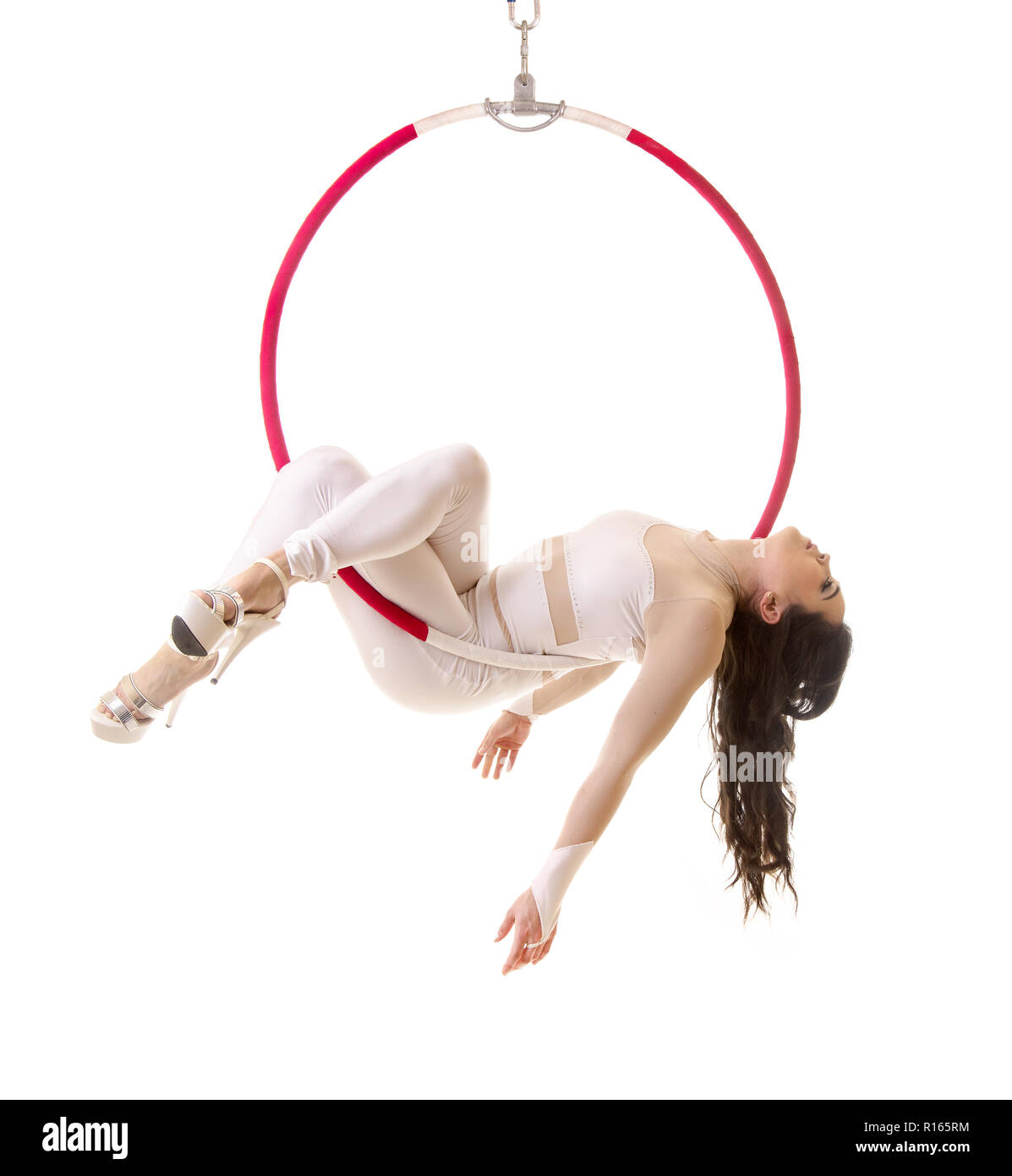 A young woman performs the acrobatic elements in the air ring. Studio ...