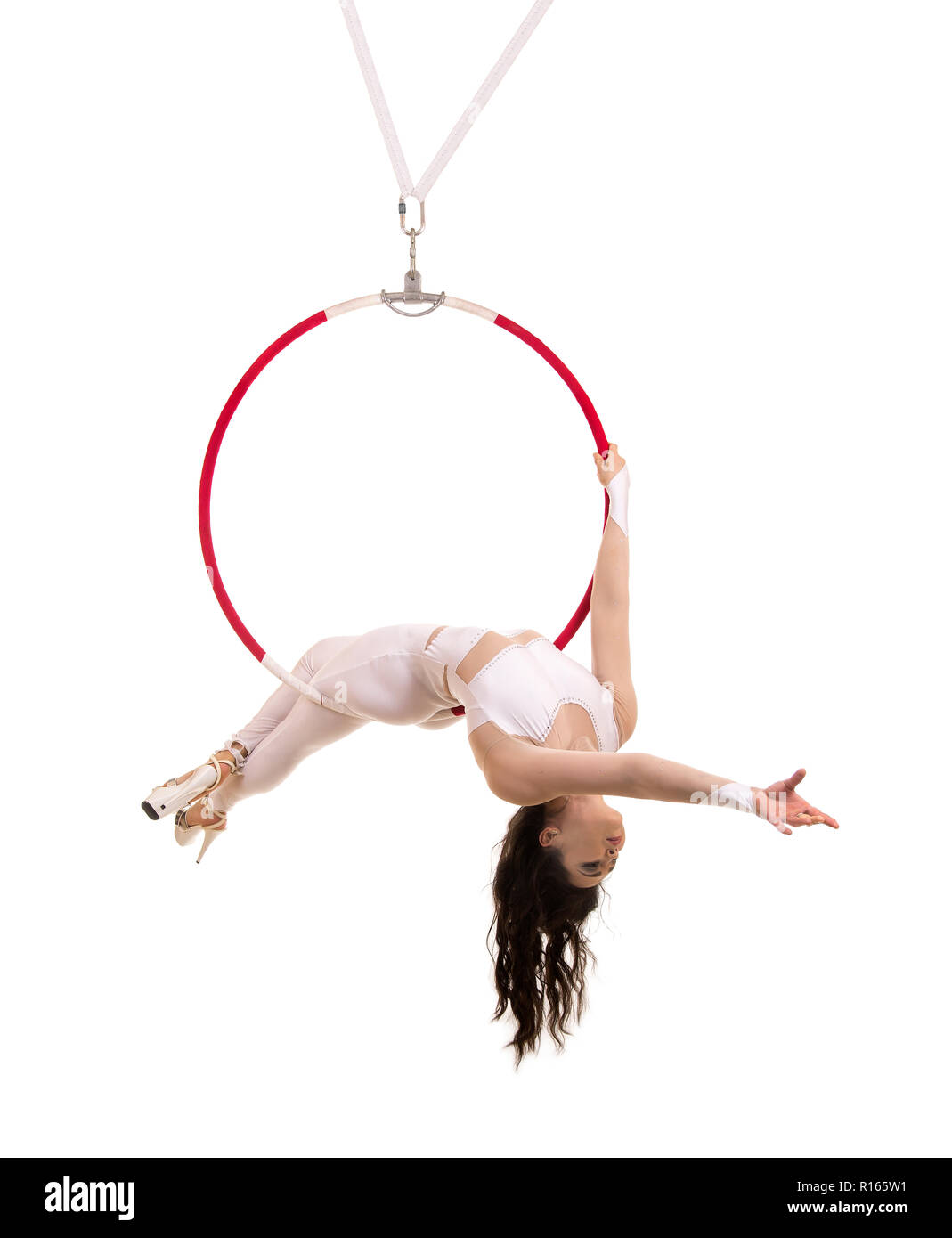 A young woman performs the acrobatic elements in the air ring. Studio ...