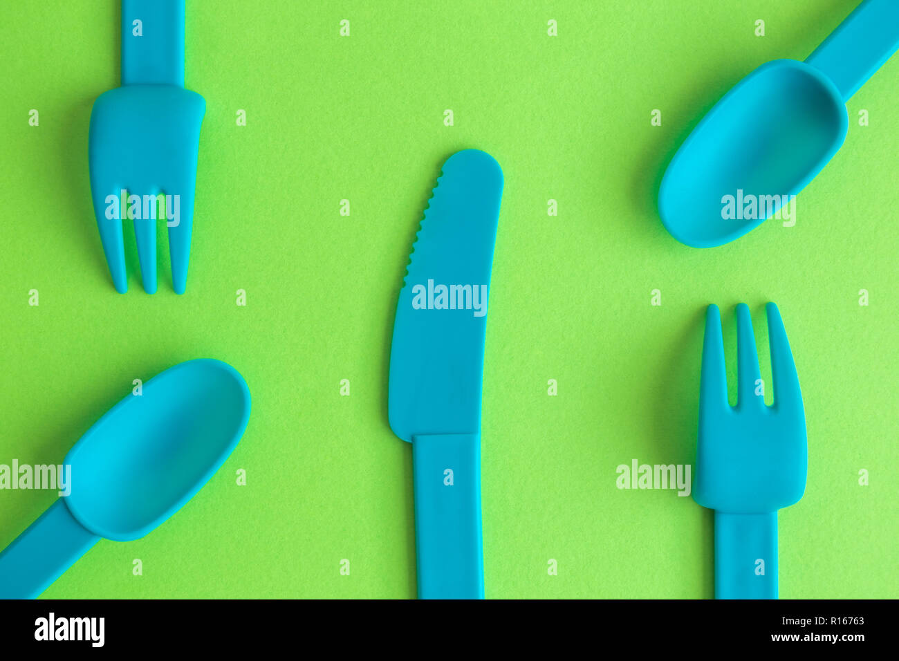 Flat lay of plastic tableware on green background, minimal food ...