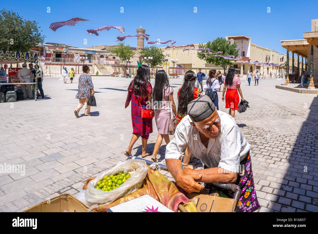 An old man selling foods and groceries on a chariot in the streets of Bukhara, Uzbekistan Stock Photo