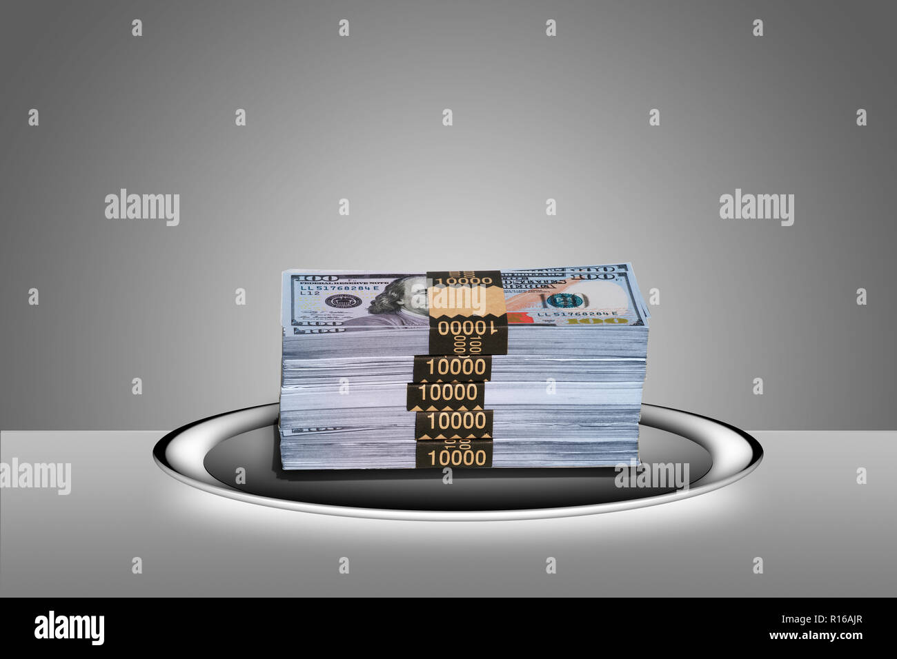 Stacked 100 dollar bills in 10,000 dollar currency straps on silver platter - 'hand to on a silver platter' Stock Photo