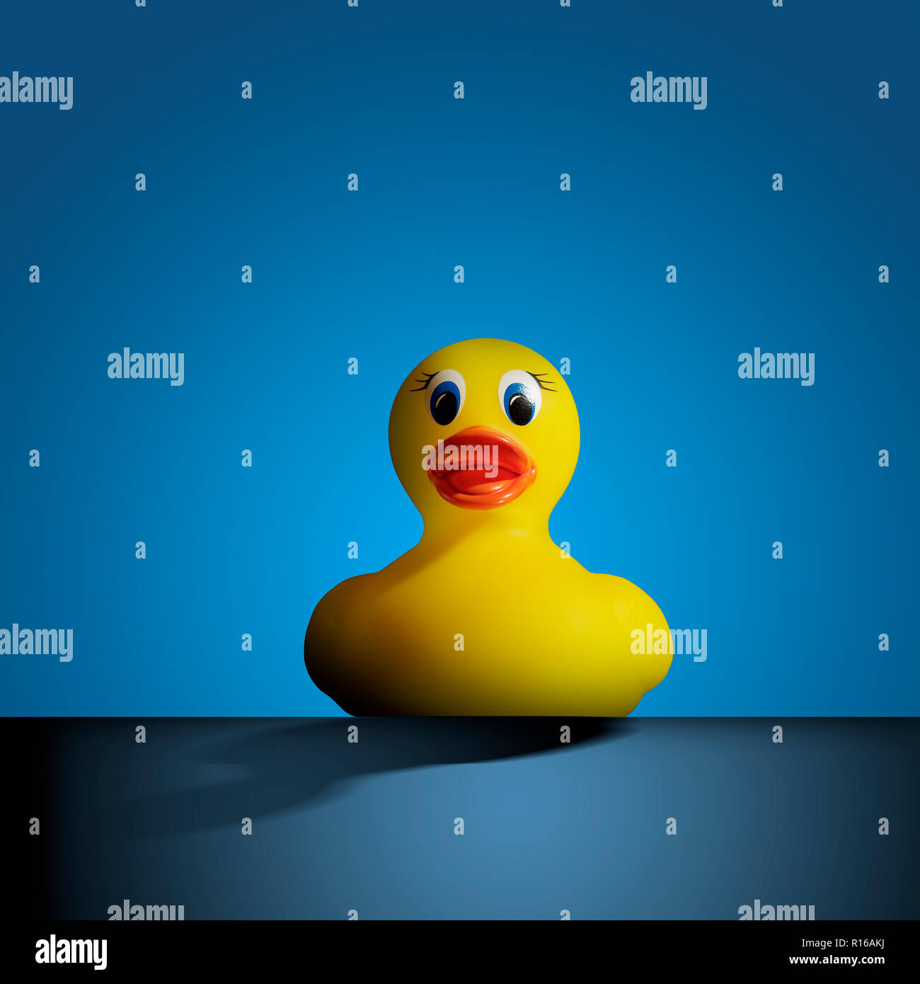 Yellow rubber duck against blue background, front view Stock Photo