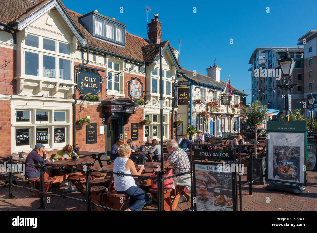 People sitting outside seafront pubs The Jolly Sailor and The Lord Nelson in Poole, Dorset, England Stock Photo