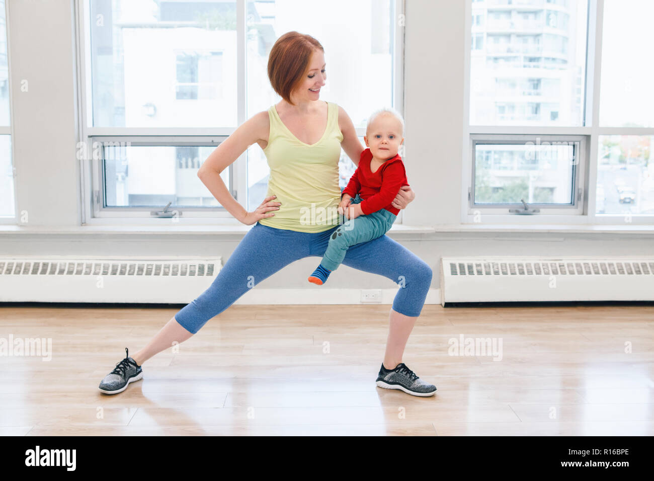 Young woman with child doing workout in gym class to loose baby