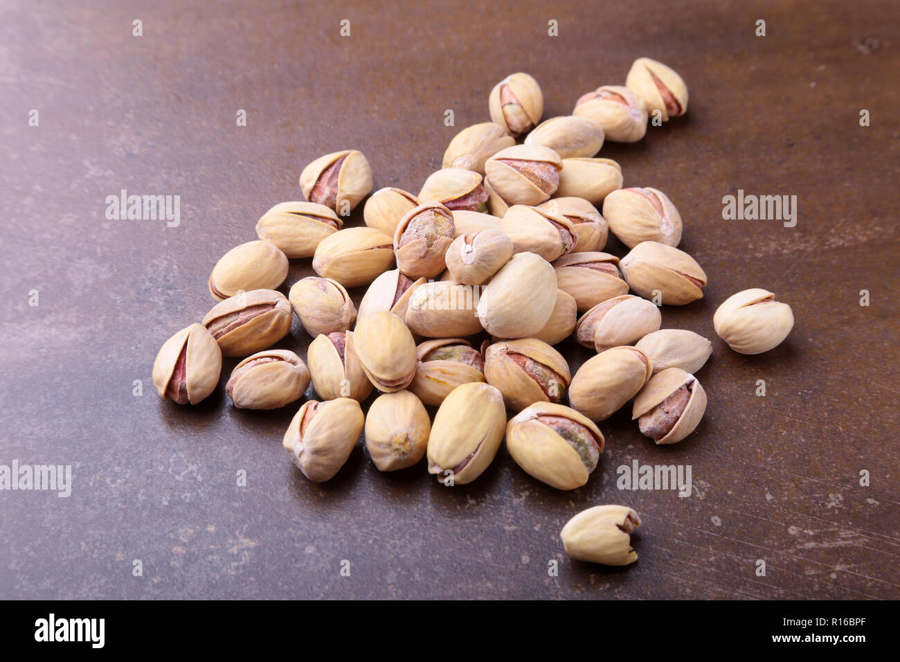 Salt pistachios on a stone table. Close-up. Stock Photo
