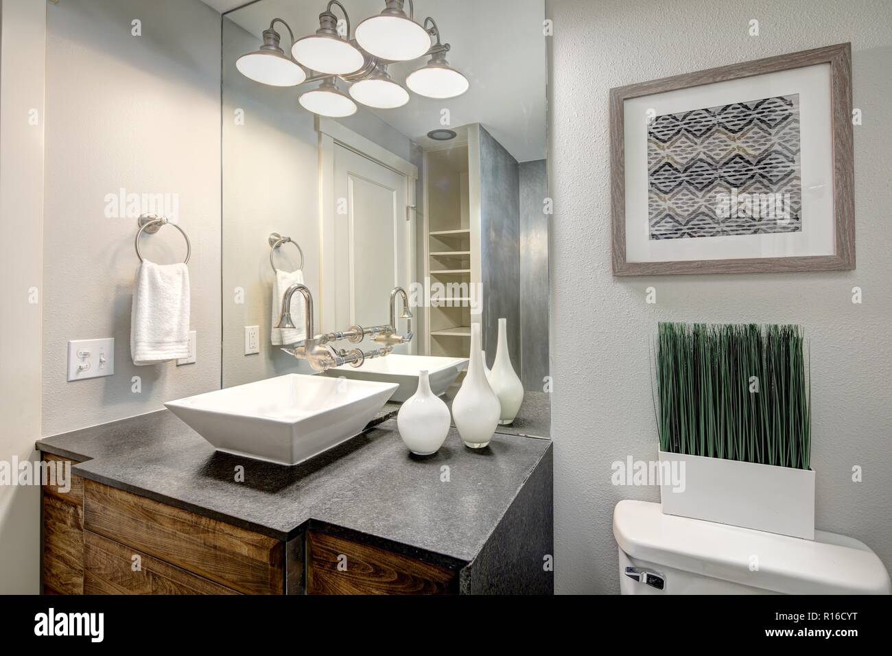 Luxurious master bathroom with grey vanity cabinet and rectangular vessel sinks. Stock Photo