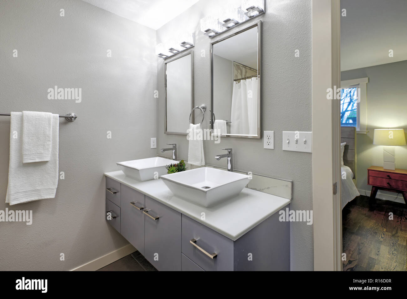 Luxurious Master Bathroom With Blue Vanity Cabinet And Two